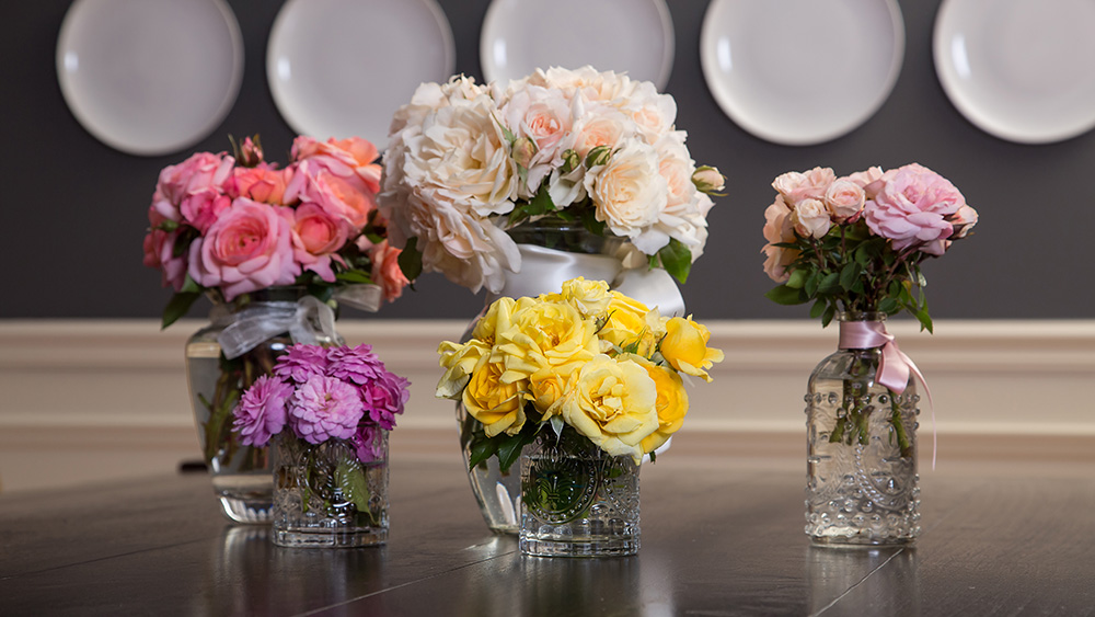 group of rose arrangements sitting on a table